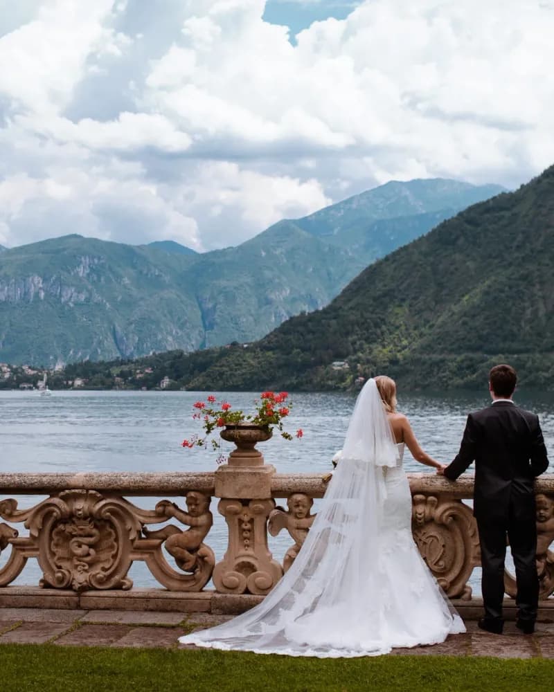 A bride and groom on a villa terrace above Lake Como