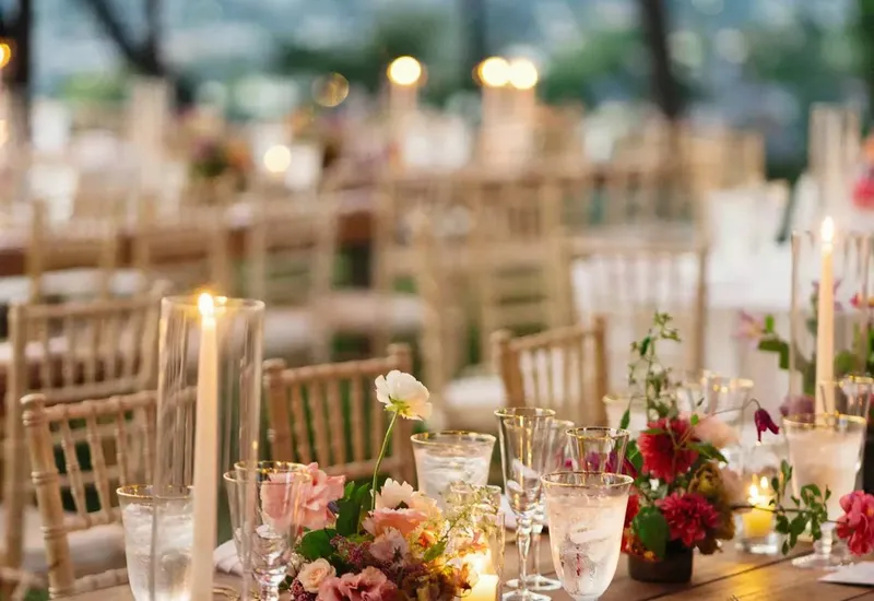 A candlelit reception table dressed with flowers
